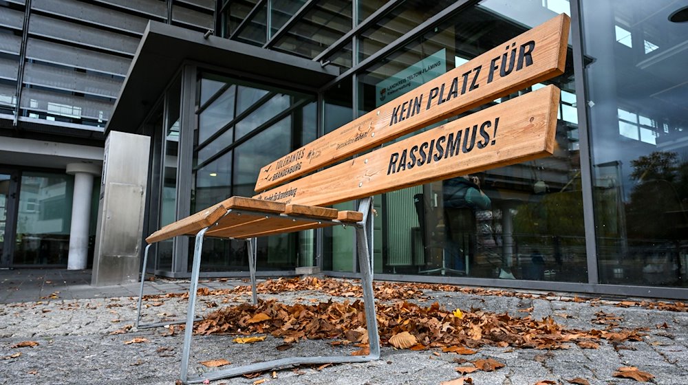 Eine Sitzbank mit der Aufschrift „Kein Platz für Rassismus!“ vor der Kreisverwaltung Teltow-Fläming und dem Sitz der Landrätin und den Ämtern. / Foto: Jens Kalaene/dpa