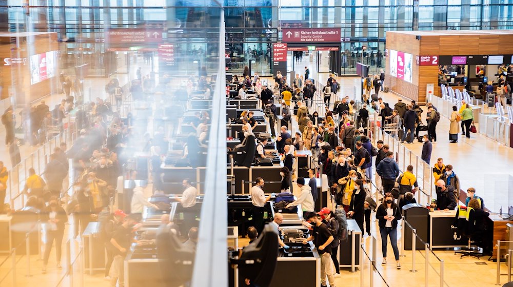 Passagiere stehen am Flughafen Berlin Brandenburg vor der Sicherheitskontrolle Schlange. / Foto: Christoph Soeder/dpa/Archivbild