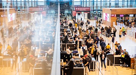 Passagiere stehen am Flughafen Berlin Brandenburg vor der Sicherheitskontrolle Schlange. / Foto: Christoph Soeder/dpa/Archivbild