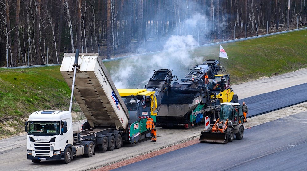 Arbeiter asphaltieren auf der A14-Baustelle die Fahrbahn der zuküftigen Autobahn. / Foto: Klaus-Dietmar Gabbert/dpa/Archivbild