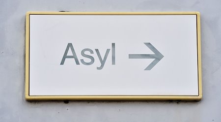 Ein Schild mit der Aufschrift «Asyl» hängt in Erstaufnahme für Asylbewerber  an einer Wand. / Foto: Uli Deck/dpa