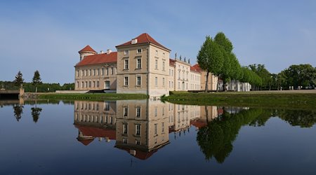 Die Parkseite von Schloss Rheinsberg mit dem Kurt Tucholsky Literaturmuseum spiegelt sich in dem vom Grienericksee gespeisten Wasser des Schlossgrabens. / Foto: Soeren Stache/dpa/Archivbild