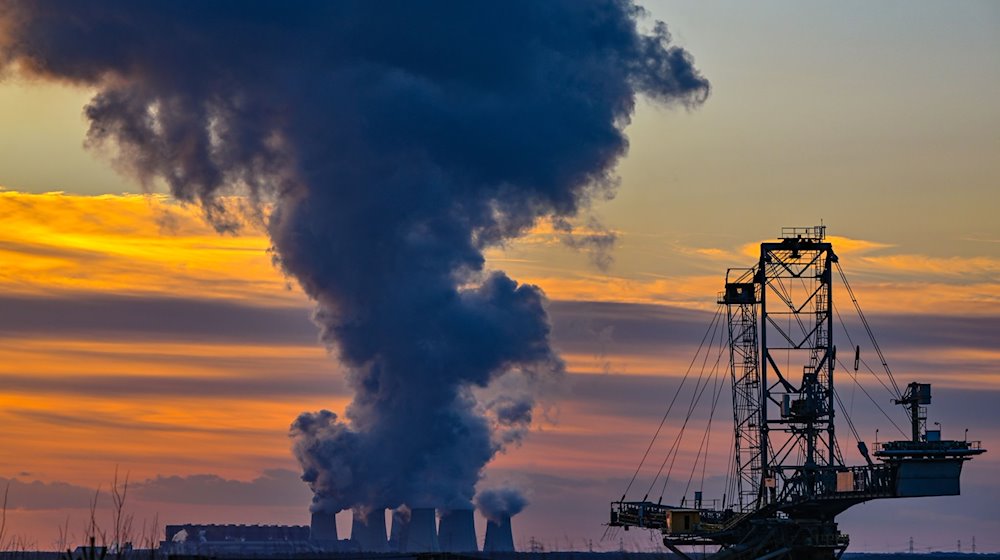 Wasserdampf steigt im Sonnenuntergang am frühen Abend aus den Kühltürmen des Braunkohlekraftwerks Jänschwalde. / Foto: Patrick Pleul/dpa