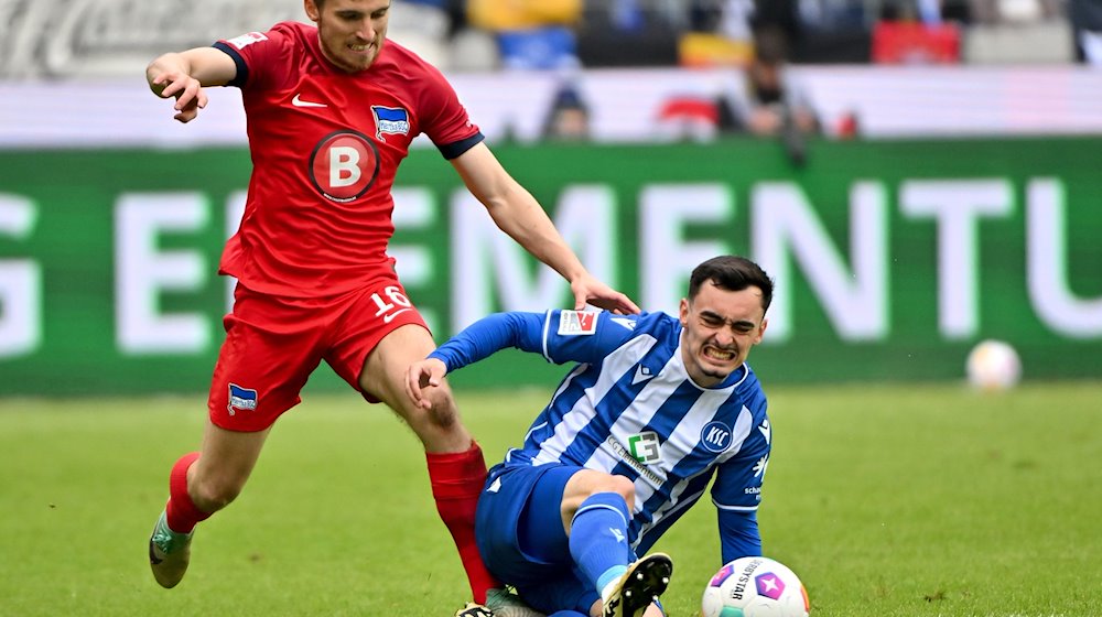 Berlins Jonjoe Kenny (l) im Zweikampf mit Paul Nebel vom Karlsruher SC. / Foto: Jan-Philipp Strobel/dpa