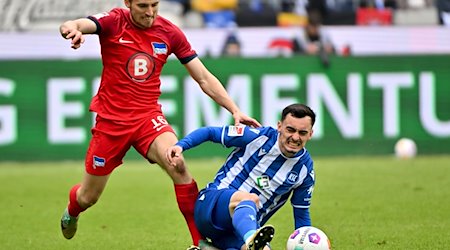 Berlins Jonjoe Kenny (l) im Zweikampf mit Paul Nebel vom Karlsruher SC. / Foto: Jan-Philipp Strobel/dpa