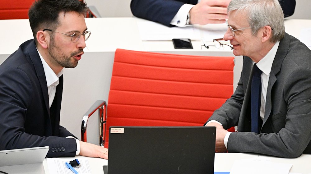 Dennis Hohloch (l) und Hans-Christoph Berndt (beide AfD) unterhalten sich bei der 99. Sitzung des Landtages Brandenburg. / Foto: Jens Kalaene/dpa