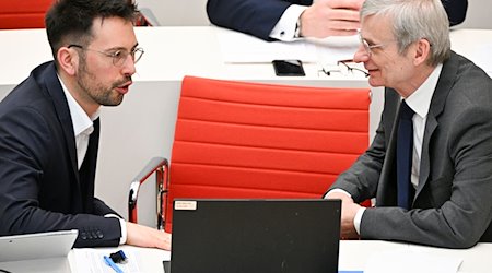 Dennis Hohloch (l) und Hans-Christoph Berndt (beide AfD) unterhalten sich bei der 99. Sitzung des Landtages Brandenburg. / Foto: Jens Kalaene/dpa