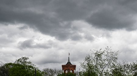 Dunkle Wolken sind über dem Roten Rathaus am Alexanderplatz zu sehen. / Foto: Jens Kalaene/dpa