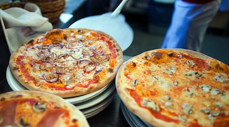 In einer Pizzeria liegen fertige Pizzen auf Tellern. / Foto: Arno Burgi/dpa-Zentralbild/dpa