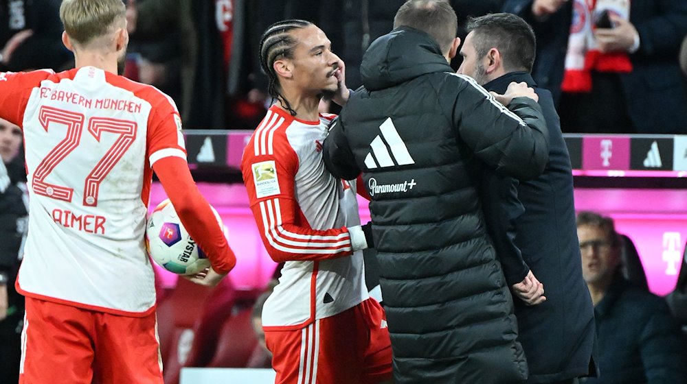 Unions Trainer Nenad Bjelica (r) greift Bayern Münchens Leroy Sane (M) ins Gesicht. / Foto: Matthias Koch/dpa