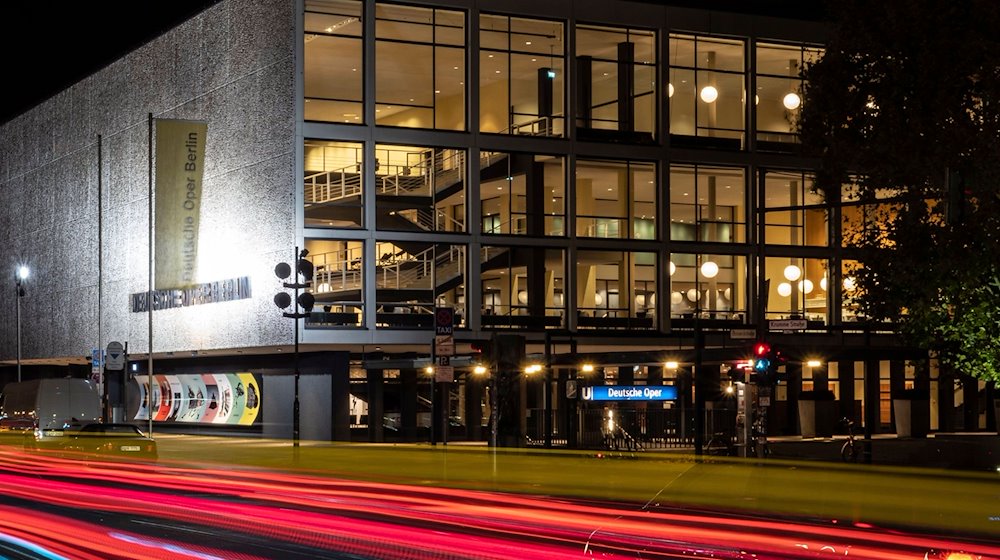 Vorbeifahrende Fahrzeuge erzeugen vor der Deutschen Oper Berlin rote Lichtstreifen. / Foto: Paul Zinken/dpa