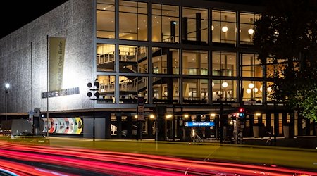 Vorbeifahrende Fahrzeuge erzeugen vor der Deutschen Oper Berlin rote Lichtstreifen. / Foto: Paul Zinken/dpa