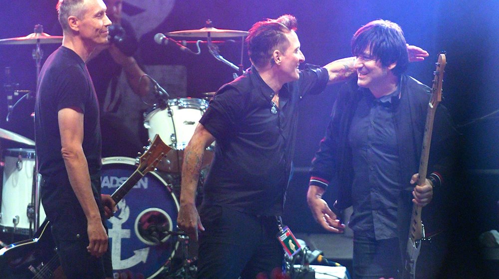 Farin Urlaub (l-r), Bela B. und Rodrigo Gonzalez von der Band Die Ärzte stehen auf der Bühne. / Foto: Axel Heimken/dpa/Archivbild