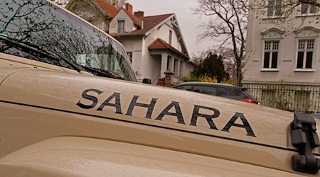 Ein sandfarbener Jeep mit der Aufschrift «Sahara» steht bei dunstigem Licht in einer Straße der Hauptstadt. / Foto: Wolfram Steinberg/dpa