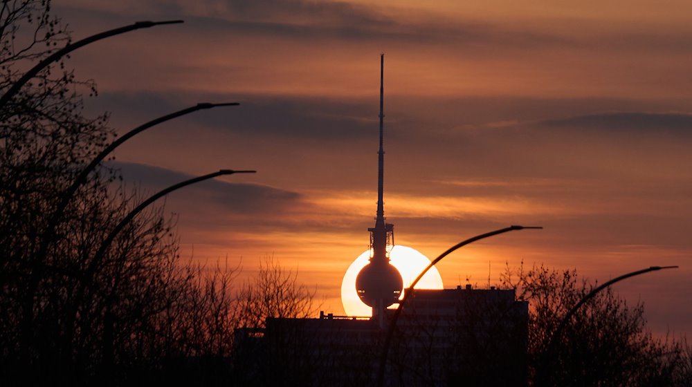 Die Sonne geht hinter dem Fernsehturm unter. / Foto: Annette Riedl/dpa