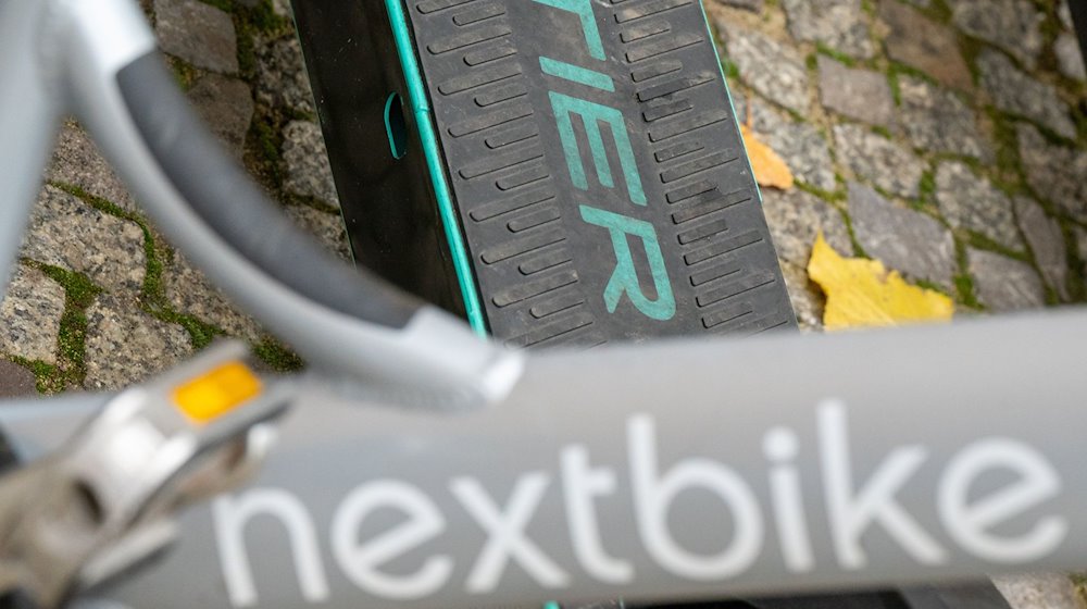 E-Tretroller des Anbieters Tier und ein Leihfahrrad von Nextbike stehen nebeneinander auf einem Gehweg. / Foto: Monika Skolimowska/dpa-Zentralbild/dpa/Archivbild