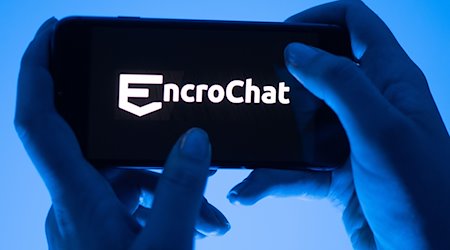 Eine Frau hält ein Smartphone mit dem Logo des Krypto-Messengerdienstes Encrochat (gestellte Szene). / Foto: Sebastian Kahnert/dpa/Illustration
