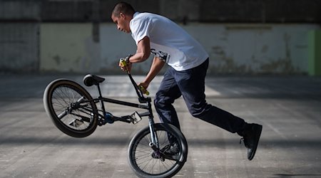 Camilo Gutierrez, ein BMX Profi, führt seine Tricks auf dem Rad vor. / Foto: Arne Immanuel Bänsch/dpa/Archivbild