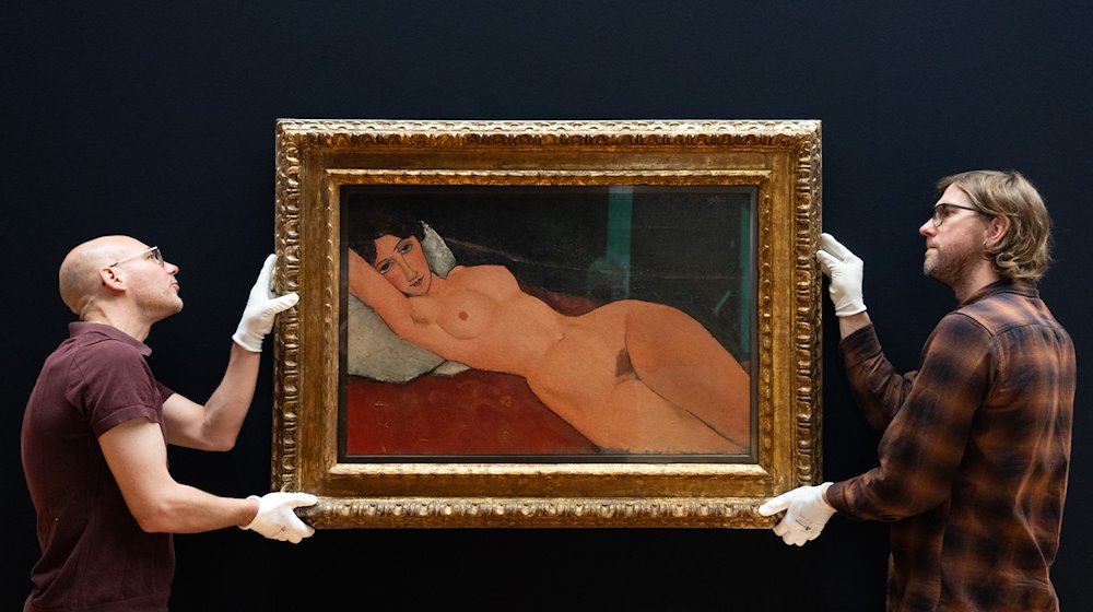 Mitarbeiter des Museums Barberini hängen in Vorbereitung der Ausstellung „Modigliani. Moderne Blicke“ das Gemälde „Liegender Frauenakt auf weißem Kissen“ (1917, Staatsgalerie Stuttgart) von Amedeo Modigliani an die Wand. / Foto: Soeren Stache/dpa/Archivbild