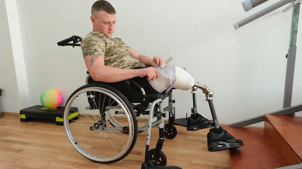 Der ukrainische Soldat Dmytro (27), der in einem Gefecht mit russischen Truppen beide Beine verloren hat, zieht seine Prothese in einem Rehabilitationszentrum in der Nähe von Lwiw an. / Foto: Mykola Tys/AP/dpa