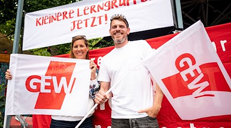 Sven und Bianca, beide Lehrer an einer Neuköllner Schule, stehen mit zwei GEW-Flaggen beim Warnstreik. / Foto: Fabian Sommer/dpa