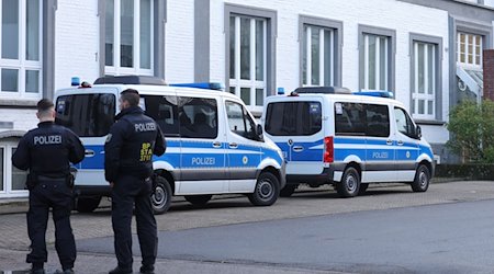 Polizisten stehen vor einem Gebäude, das durchsucht wird. / Foto: Gianni Gattus/dpa