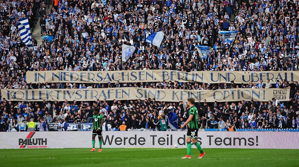 Hertha-Fans zeigen den Schriftzug "In Niedersachsen, Berlin und überall - Kollektivstrafen sind keine Option". / Foto: Soeren Stache/dpa