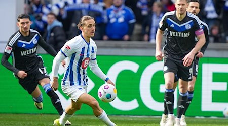 Herthas Michal Karbownik (M) nimmt den Ball vor Simon Terodde (r) von Schalke an. / Foto: Soeren Stache/dpa