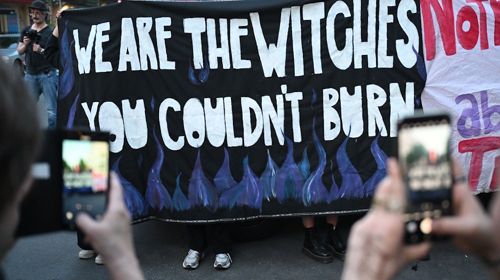 «We are witches you couldn’t burn» steht während der Frauen-Demo «Take back the night» auf einem Banner. / Foto: Sebastian Christoph Gollnow/dpa