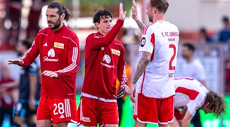 Berlins Christopher Trimmel (l-r), Brenden Aaronson und Kevin Vogt klatschen sich nach dem Spiel ab. / Foto: Andreas Gora/dpa