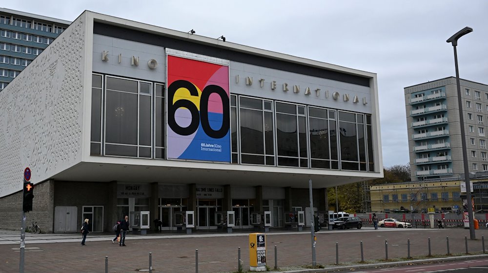 Das Kino International an der Karl-Marx-Allee weist mit einem neuen Plakat an seiner Fassade auf sein 60. Jubiläum hin. Das Kino war das wichtigste Premierenkino der DDR. Es steht vor einer großen Sanierung. / Foto: Jens Kalaene/dpa