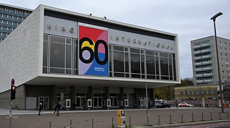 Das Kino International an der Karl-Marx-Allee weist mit einem neuen Plakat an seiner Fassade auf sein 60. Jubiläum hin. Das Kino war das wichtigste Premierenkino der DDR. Es steht vor einer großen Sanierung. / Foto: Jens Kalaene/dpa