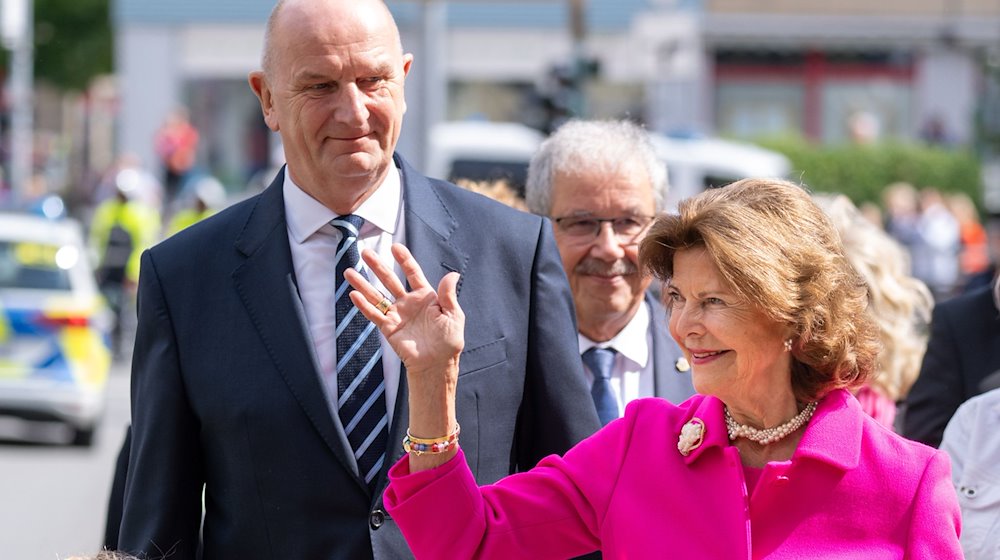 Königin Silvia von Schweden (r) und Dietmar Woidke (l, SPD), Ministerpräsident von Brandenburg, kommen zur feierlichen Eröffnung des Wohnquartiers für an Demenz erkrankte Menschen. / Foto: Monika Skolimowska/dpa