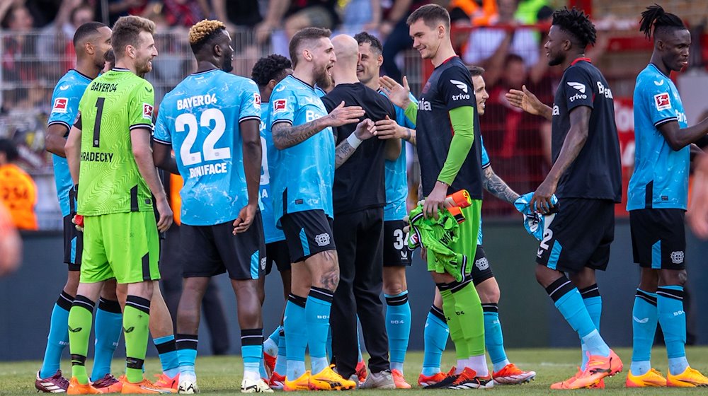 Leverkusens Spieler klatschen sich nach dem Sieg ab. / Foto: Andreas Gora/dpa