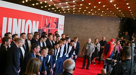 Der Cast und die Mannschaft von Union Berlin stehen bei der Filmpremiere auf dem roten Teppich im Kino International. / Foto: Jens Kalaene/dpa