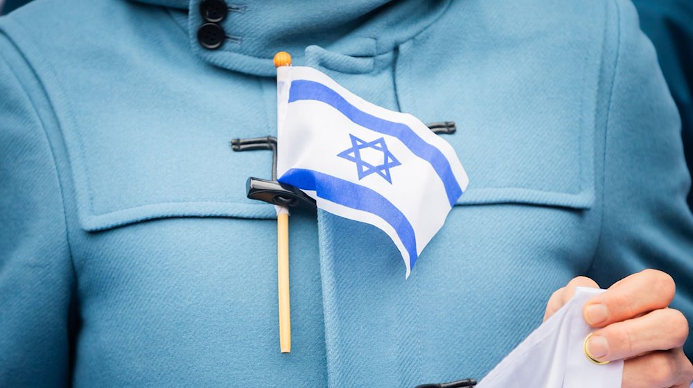 Eine Israel-Flagge steckt bei einem stillen Protest einer Initiative für die Sicherheit jüdischer Studierender an der Freien Universität Berlin an der Jacke eines Teilnehmers. / Foto: Christoph Soeder/dpa