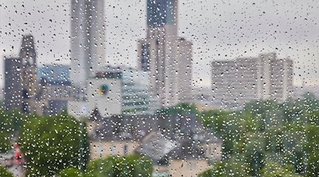 Regentropfen sind an einer Fensterscheibe vor der Skyline der City West zu sehen. / Foto: Jörg Carstensen/dpa