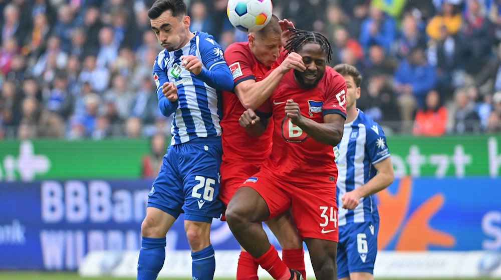 Paul Nebel (l) vom Karlsruher SC im Zweikampf mit Berlins Palko Dardai (M) und Berlins Deyovaisio Zeefuik. / Foto: Jan-Philipp Strobel/dpa