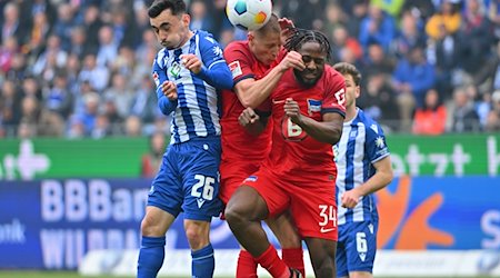 Paul Nebel (l) vom Karlsruher SC im Zweikampf mit Berlins Palko Dardai (M) und Berlins Deyovaisio Zeefuik. / Foto: Jan-Philipp Strobel/dpa