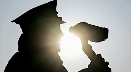 Ein Polizist kontrolliert mit einer Laserpistole Geschwindigkeiten. / Foto: Patrick Pleul/dpa-Zentralbild/dpa/Symbolbild