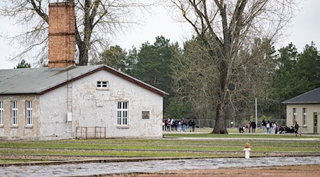 Personen laufen in der Gedenkstätte Sachsenhausen über das Gelände des ehemaligen Konzentrationslager. / Foto: Fabian Sommer/dpa