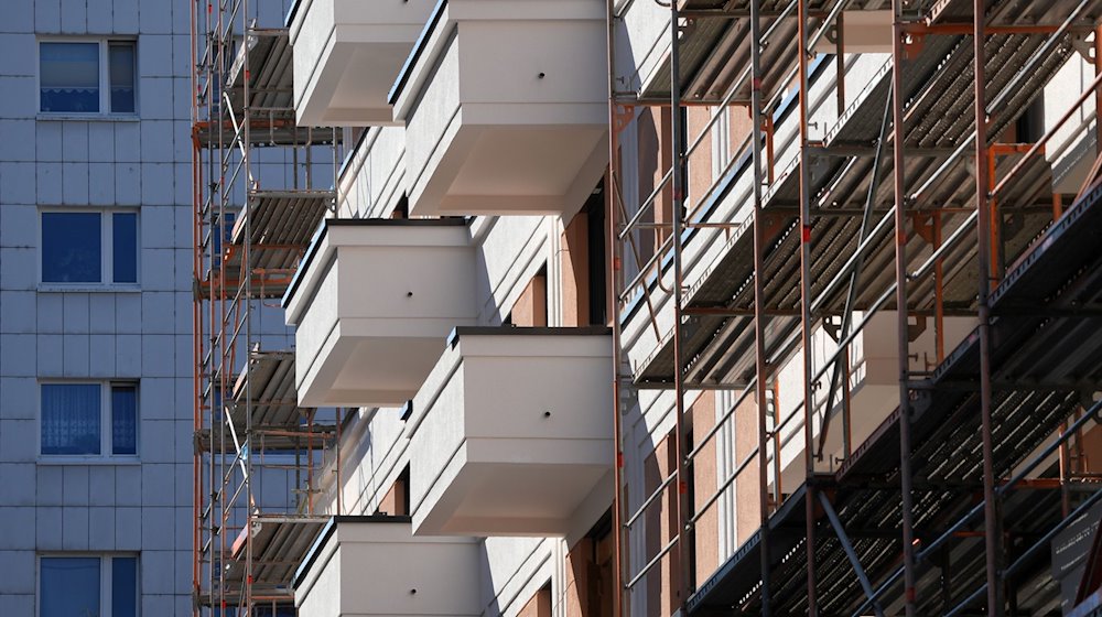 Das Baugerüst an einem Wohnhaus am Franz-Mehring-Platz ist teilweise abgebaut. / Foto: Soeren Stache/dpa