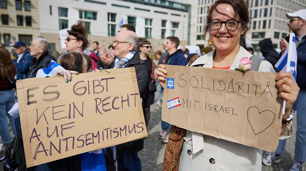 Teilnehmerinnen einer Solidaritätsdemonstration der Deutsch-Israelischen Gesellschaft (DIG) unter dem Motto »Hands off Israel» auf dem Pariser Platz halten Plakate mit der Aufschrift "Es gibt kein Recht auf Antisemitismus" und "Solidarität mit Israel". / Foto: Jörg Carstensen/dpa