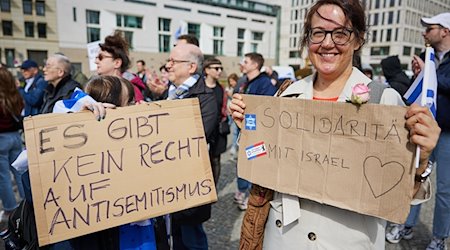 Teilnehmerinnen einer Solidaritätsdemonstration der Deutsch-Israelischen Gesellschaft (DIG) unter dem Motto »Hands off Israel» auf dem Pariser Platz halten Plakate mit der Aufschrift "Es gibt kein Recht auf Antisemitismus" und "Solidarität mit Israel". / Foto: Jörg Carstensen/dpa