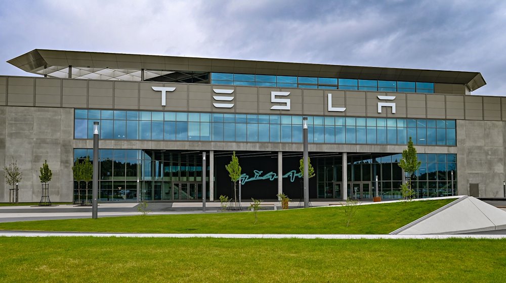 Dunkle Wolken ziehen über das Werk der Tesla-Autofabrik. / Foto: Patrick Pleul/dpa/Archivbild