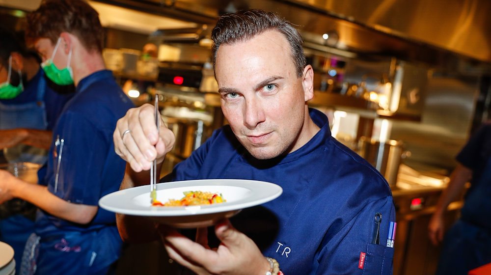 Der Berliner Spitzenkoch Tim Raue präpariert ein Essen in der Küche. / Foto: Gerald Matzka/dpa-Zentralbild/dpa