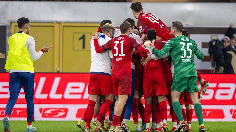 Berlins Spieler jubeln nach dem Tor zum 2:3. / Foto: David Inderlied/dpa