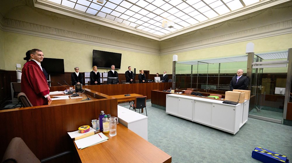 Die Vertreter der Anklage, Lars Malskies (l), Oberstaatsanwalt beim BGH, und Staatsanwalt Cai Rüffer (2.v.l.), sowie der Anwalt von Arthur E., stehen zusammen. / Foto: Bernd von Jutrczenka/dpa Pool/dpa