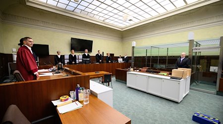 Die Vertreter der Anklage, Lars Malskies (l), Oberstaatsanwalt beim BGH, und Staatsanwalt Cai Rüffer (2.v.l.), sowie der Anwalt von Arthur E., stehen zusammen. / Foto: Bernd von Jutrczenka/dpa Pool/dpa