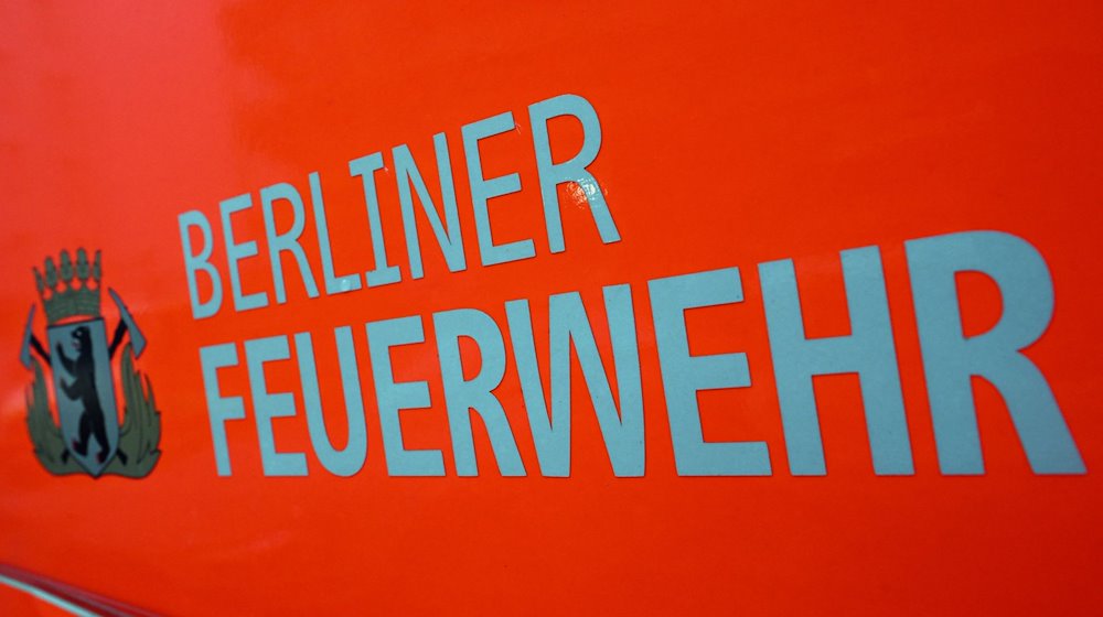 Der Schriftzug „Berliner Feuerwehr“ und das Wappen Berliner Feuerwehr mit dem Berliner Bären stehen auf der Tür eines Feuerwehrfahrzeuges. / Foto: Soeren Stache/dpa/Archivbild